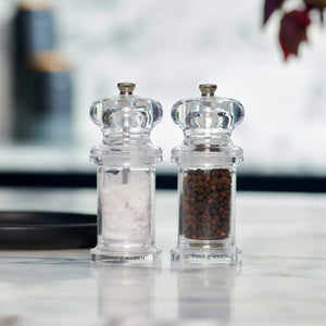 #pepper
The Cole & Mason 505 Salt & Pepper Mills, featuring a sleek clear acrylic design, are displayed side by side—one filled with salt, the other with peppercorns—on a marble countertop with a blurred background.