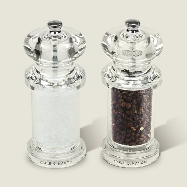 #salt&pepperset
The Cole & Mason 505 Salt & Pepper Mills, crafted from clear acrylic, sit side by side—one with white salt crystals, the other with whole black peppercorns—and feature adjustable settings.