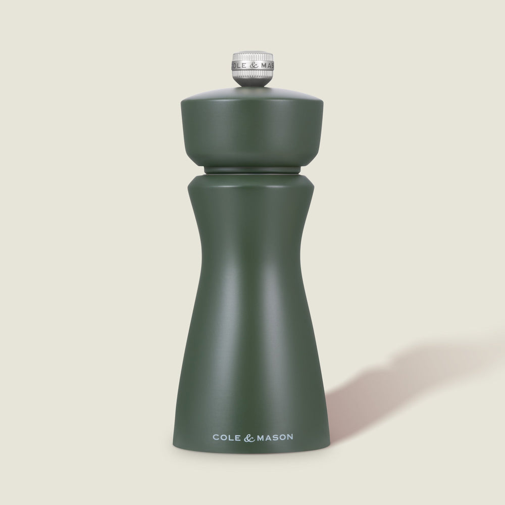 The Cole & Mason Kenton Rosemary Salt & Pepper Mill in matte sage green with a silver top and ceramic mechanism stands upright against a light off-white background.