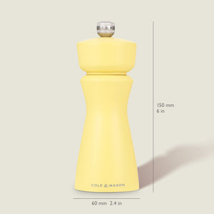The Cole & Mason Kenton Salt & Pepper Mill in Turmeric Yellow stands upright on a light background, measuring 150 mm tall and 60 mm wide, featuring a silver top knob, ceramic mechanism, and the brand name on its base.